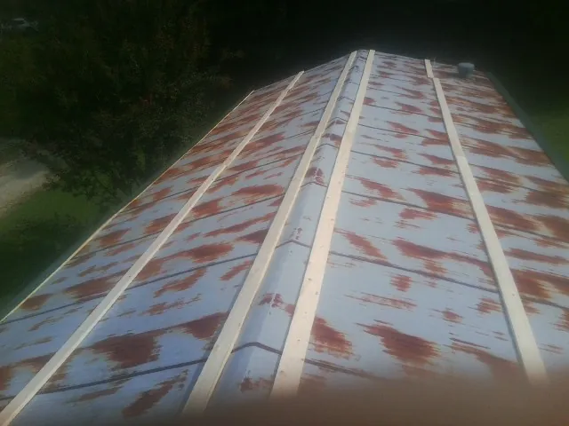 Rusted metal roof panels with new wood purlins before replacement — Storm Damage Roof Repair in Millburn by Roofing Brothers