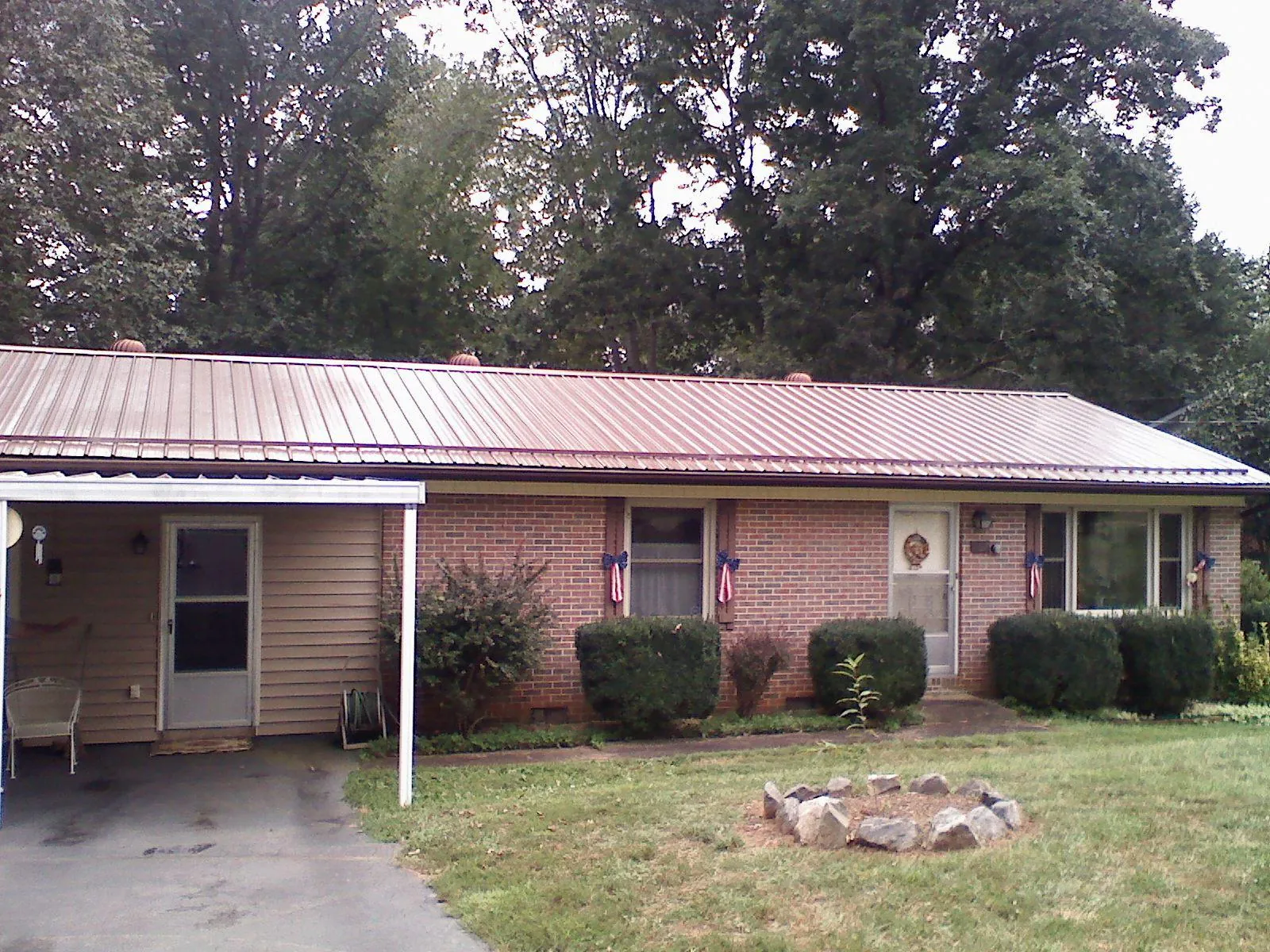 Bronze metal roof and carport on a brick ranch home — Roof Repair work by our crew in Millburn